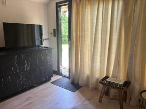 a living room with a flat screen tv on a dresser at B&B Sonnegaerde in Arnhem