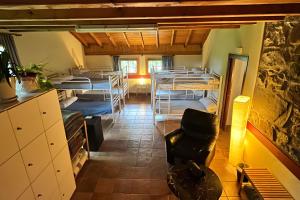 a room with several bunk beds and a chair at Sallobante Aterpetxea - Casa in Mechicas