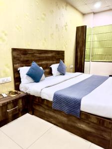 ein Schlafzimmer mit zwei Betten und blauen Kissen in der Unterkunft Hotel De Agya in Ludhiana