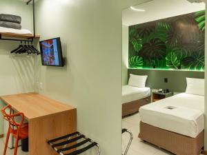 a room with two beds and a table and a desk at ibis Styles Belém do Pará in Belém