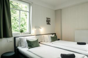 two beds in a room with two windows at KRUSHPOINT Krušnohorský hotel in Horní Blatná