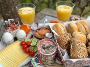 a table with a tray of food and two glasses of orange juice at B&B Sonnegaerde in Arnhem