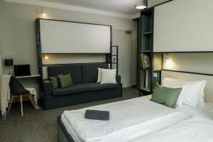 a hotel room with a bed and a couch at KRUSHPOINT Krušnohorský hotel in Horní Blatná