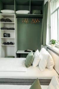 a bedroom with a bed with pillows and a table at KRUSHPOINT Krušnohorský hotel in Horní Blatná