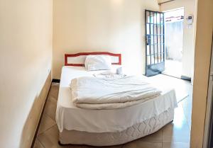 a bedroom with a bed with white sheets at Wenyeji Inn Hotel Moshi in Moshi