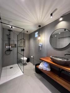 a bathroom with a sink and a mirror at TERPOU StoneHouse & Suites in Volos
