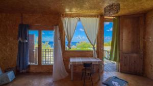 a room with a table and a large window at Cap carav'ânes in Banī ‘Aţāʼ +56 photos