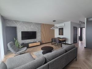 a living room with a couch and a tv at Apartamenty I.M.A Towarowa in Poznań