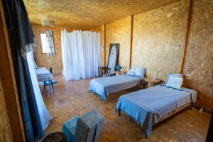 a room with two beds and a table at Cap carav'ânes in Banī ‘Aţāʼ