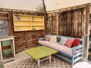 a porch with a couch and a table at Cap carav'ânes in Banī ‘Aţāʼ