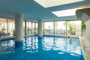 a large swimming pool with columns in a building at Mondial Beauty Suite in Bellaria-Igea Marina