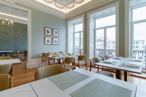 ein Esszimmer mit Tischen, Stühlen und Fenstern in der Unterkunft SAL Collection Hotel in Aveiro