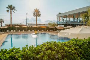 a large swimming pool with umbrellas and a resort at Era Palace Gonio in Kvariati