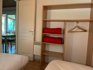 a bedroom with a bed and a red pillow on shelves at SAS Le Bataillet in Montégut