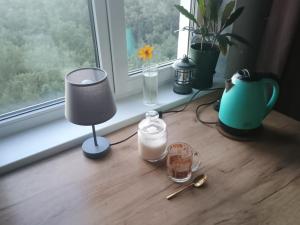 a window sill with a table with a lamp and a candle at Уютная комната в квартире в ЖК Одесский Бульвар in Teremki +1 photo