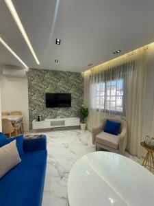 a living room with a couch and a tv on a wall at Appartement direct aan zee in Azla-Tetouan in Azla