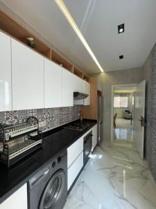 a kitchen with a washer and dryer on a counter at Appartement direct aan zee in Azla-Tetouan in Azla