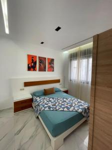 a bedroom with a bed with a blue comforter at Appartement direct aan zee in Azla-Tetouan in Azla
