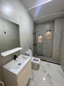a bathroom with a sink and a toilet and a shower at Appartement direct aan zee in Azla-Tetouan in Azla +15 photos