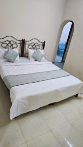 two beds with white sheets and pillows in a room at Value Stays By Amisha Palace in Jaipur