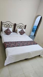 a bedroom with two beds with white sheets and pillows at Value Stays By Amisha Palace in Jaipur