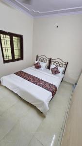 a bedroom with a bed with white sheets and a window at Value Stays By Amisha Palace in Jaipur
