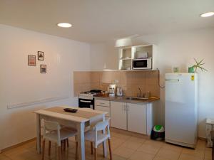 a small kitchen with a table and a white refrigerator at Cabañas Aluen in El Calafate