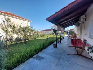 a patio with a bench under awning next to a yard at Marialena's houses in Methoni