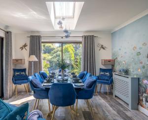 a dining room with a table and blue chairs at Otterpoint Waterfront & Pool Retreat in Tayvallich