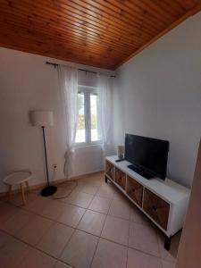 a living room with a flat screen tv on a cabinet at Marialena's houses in Methoni