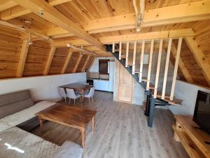 a room with a couch and a table and a staircase at Koliba SAN in Žabljak