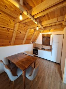 a kitchen with a wooden table and chairs in a room at Koliba SAN in Žabljak +8 photos