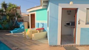 a blue house with a staircase next to a pool at Mizpah Self Catering Accommodation in Walvis Bay