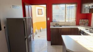 a kitchen with a stainless steel refrigerator and red walls at Mizpah Self Catering Accommodation in Walvis Bay