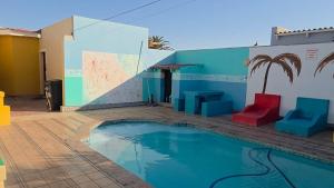 a pool with colorful furniture next to a building at Mizpah Self Catering Accommodation in Walvis Bay