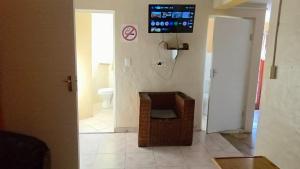 a bathroom with a toilet and a tv on the wall at Mizpah Self Catering Accommodation in Walvis Bay