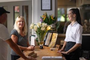 two women standing around a table with a man at Fox & Hounds Country Hotel in Chulmleigh