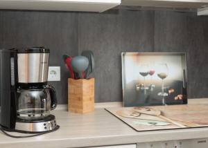 a kitchen counter with a blender and a picture of wine glasses at Auszeit an der Jümme in Detern