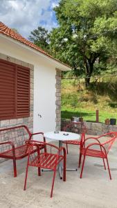 two red chairs and a table and a table and chairs at Vrela vacation in Vrela +5 photos