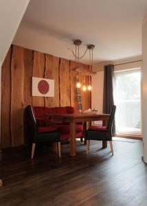 a dining room with a table and a red couch at Auszeit an der Jümme in Detern