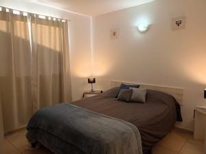 a bedroom with a bed in a room with a window at Cabañas Aluen in El Calafate