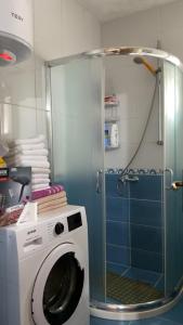 a washing machine in a bathroom with a shower at Vrela vacation in Vrela