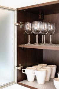a row of wine glasses and bowls on a shelf at CROSS SQUARE HOUSE - Spacious 2 Level Home, 2BR, 3Baths, Terrace - by RealTrust in Timişoara +77 photos