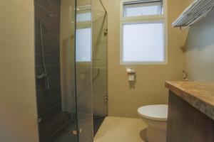 a bathroom with a shower with a toilet and a window at Nhật Vy 1 Đà Lạt in Ấp Ða Lợi