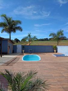 a patio with a small blue pool in a yard at Pousada Fernandes in Três Corações