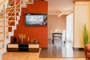 a living room with a tv on a wall at CROSS SQUARE HOUSE - Spacious 2 Level Home, 2BR, 3Baths, Terrace - by RealTrust in Timişoara