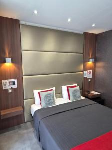 a bedroom with a large bed with two pillows at Hotel Schtak in Cannes