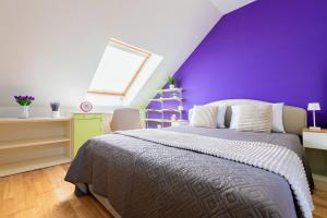 a bedroom with a purple wall and a bed at CROSS SQUARE HOUSE - Spacious 2 Level Home, 2BR, 3Baths, Terrace - by RealTrust in Timişoara
