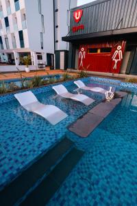 a swimming pool with two lounge chairs in a building at 1 bedroom unit with a sunrise view in Tatu City
