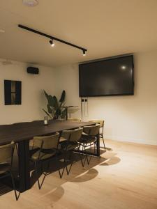 ein Konferenzraum mit Tisch, Stühlen und einem großen Bildschirm in der Unterkunft Designhotel Beila in Bilzen